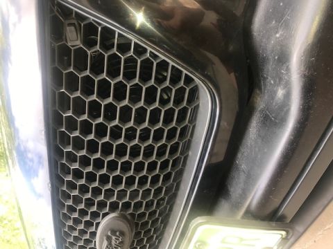 2000 Ford Explorer - Close-up front view of a black Ford Explorer grille with a honeycomb pattern. A license plate is visible on the lower left side of the bump…