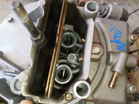 1994 Ford Bronco - Close-up view of a carburetor, showing internal mechanisms and some blue writing on the casing.