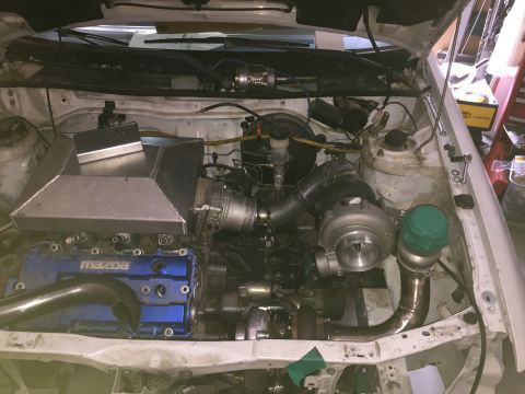 1993 Mercury Tracer - Customized engine bay with twin turbochargers and a blue Mazda valve cover is visible.