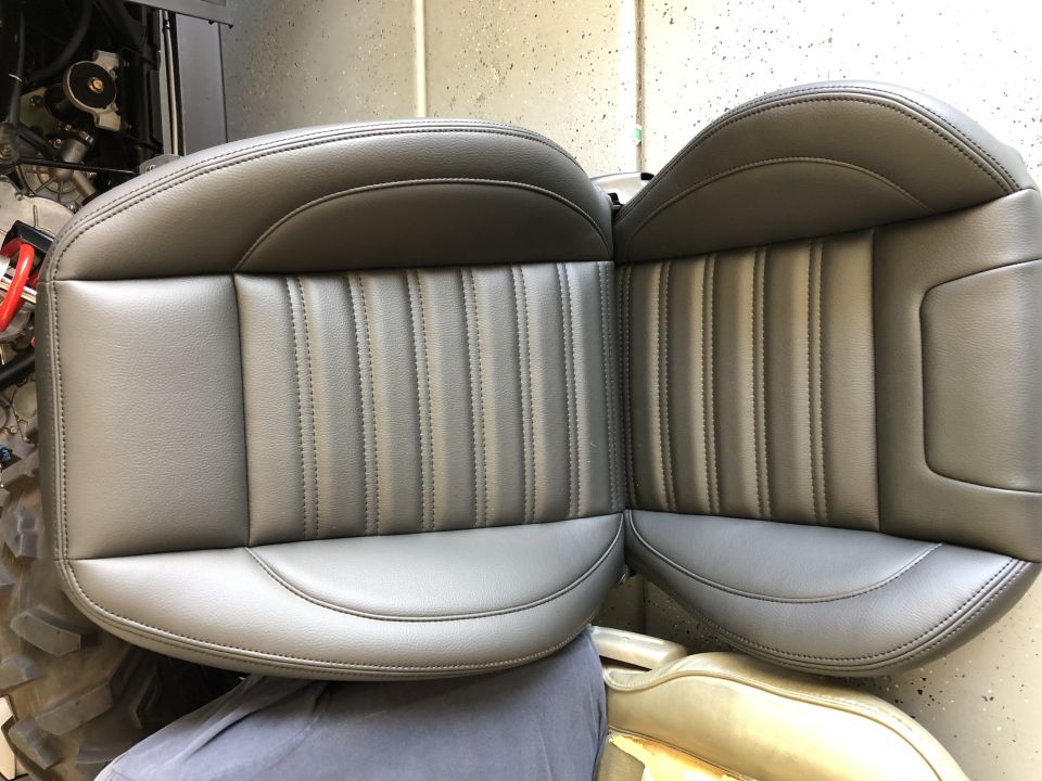 Two gray bucket seats with vertical stitching on the backrests