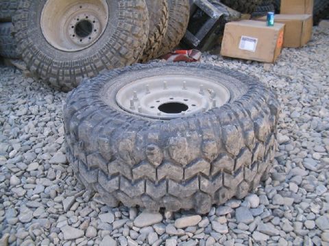 1981 Ford Bronco - A single off-road tire and wheel sits on a bed of gravel, with other tires visible in the background.
