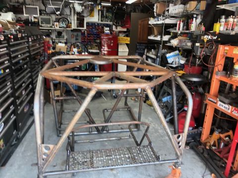 1992 Jeep Wrangler - A custom-built roll cage frame is shown in a cluttered garage setting.