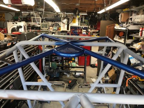 1992 Jeep Wrangler - A custom roll cage is partially painted in a cluttered garage setting.