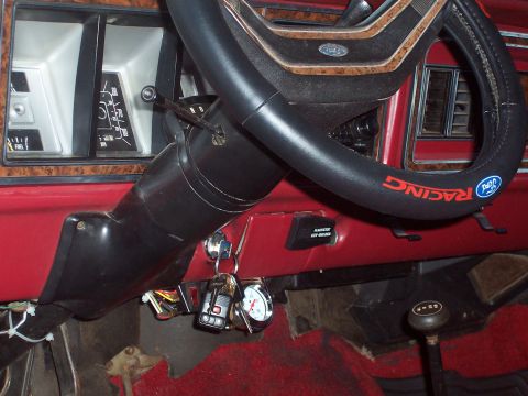 1979 Ford Bronco - Dashboard and steering wheel of a 1979 Ford Bronco, wood-grain accents and a "RACING" branded steering wheel cover.