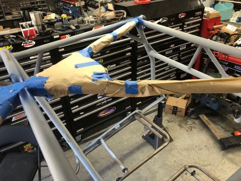 1992 Jeep Wrangler - Roll cage tubing is masked with paper and tape, ready for painting in a garage setting.