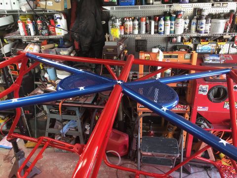 1992 Jeep Wrangler - A custom red and blue roll cage with white stars is shown in a garage setting.