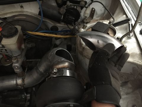 1993 Mercury Tracer - Custom turbo piping installation in an engine bay, with a gloved hand holding a section of the pipe.