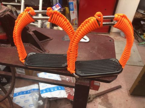 1992 Jeep Wrangler - Two grab handles wrapped in orange paracord sit on a workbench.