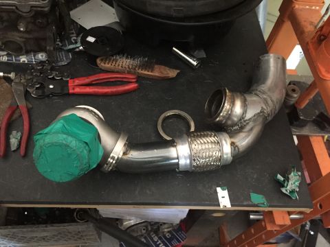 1993 Mercury Tracer - Custom exhaust pipe assembly with turbocharger components and various tools laid out on a workbench.