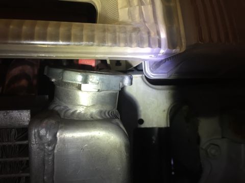 1993 Mercury Tracer - Close-up view of a radiator cap and part of a headlight assembly.