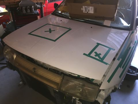 1993 Mercury Tracer - A white car's hood is marked with green tape, obscuring its original details.