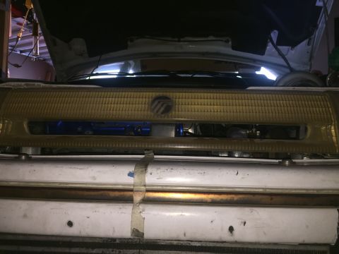 1993 Mercury Tracer - The front grille of a 1993 Mercury Tracer is visible, with some engine components behind it.