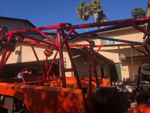 1992 Jeep Wrangler - Custom roll cage installed on an off-road vehicle, with a residential background.
