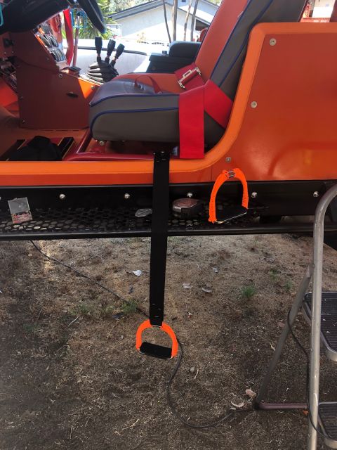 1992 Jeep Wrangler - The interior of an orange Jeep is shown, custom seats and grab handles with straps.