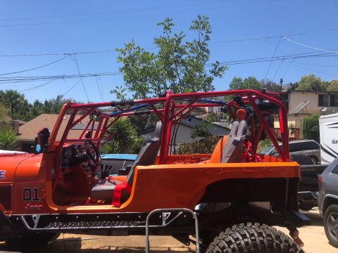 1992 Jeep Wrangler - This orange Jeep CJ-7 features a prominent red roll cage and custom side steps.