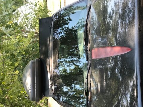 2000 Ford Explorer - A black SUV is viewed from the side, with trees reflected in the windshield.
