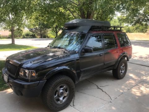 2000 Ford Explorer - This 2000 Ford Explorer is equipped with a roof box and rack, suggesting it is ready for adventure.