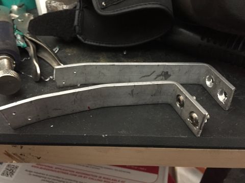 1993 Mercury Tracer - Two metal brackets with multiple holes are shown on a workbench.