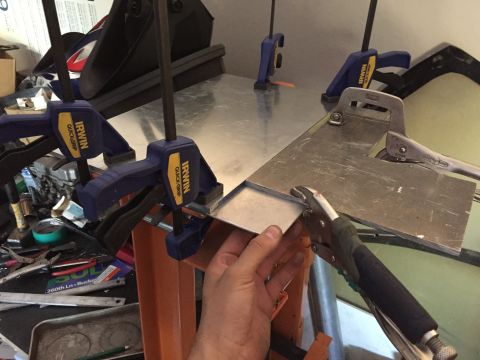 1993 Mercury Tracer - Sheet metal is being bent and shaped using Irwin QuickGrip clamps and vise grips on a workbench.
