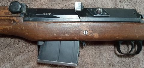 2003 Ford F-250 - A close-up view of a rifle's wooden stock and metal receiver, with a visible serial number.