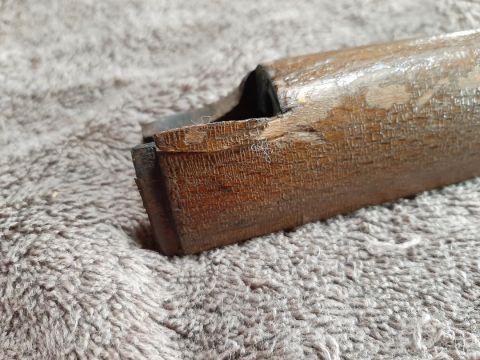 2003 Ford F-250 - Close-up of a weathered wooden component a metal insert, resting on a fuzzy textile surface.