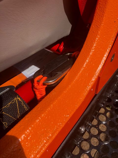 1992 Jeep Wrangler - Close-up view of an orange interior component with a seatbelt and paracord detail.