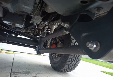 2001 Ford Excursion - The underside of a vehicle shows complex suspension and drivetrain components.