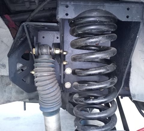 2001 Ford Excursion - Close-up of the front suspension system on a 2001 Ford Excursion, showing the coil spring and shock absorber.