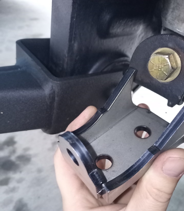 Metal bracket held by hand, attached to a black hitch receiver