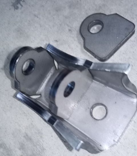2001 Ford Excursion - Two metal bracket parts are shown on a concrete surface.