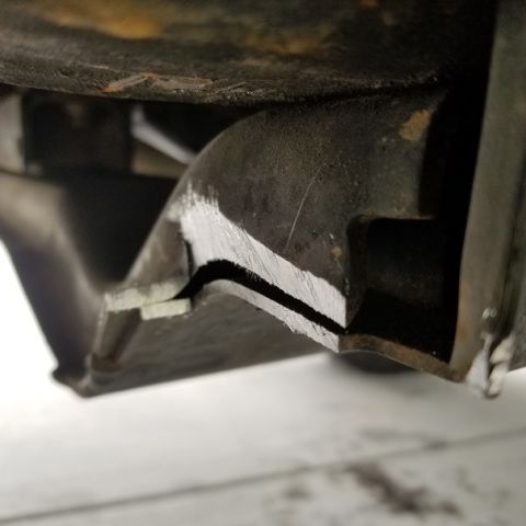 2001 Ford Excursion - A close-up view of a vehicle's frame, showing a cut metal component.