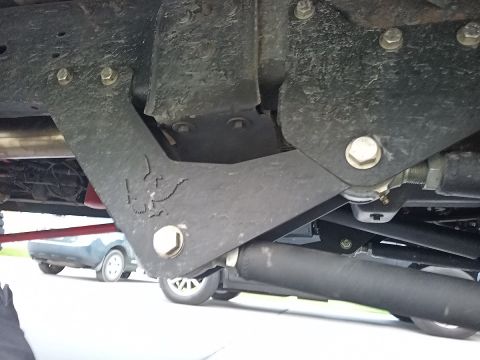 2001 Ford Excursion - A close-up view of a vehicle's undercarriage, with another car visible in the background.