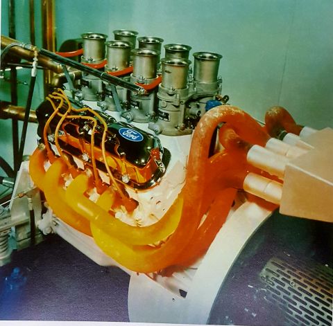 1973 Ford Mustang - A Ford V8 engine is shown with chrome valve covers, multiple carburetors, and custom orange exhaust headers.