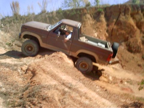 1985 Ford Bronco - A 1985 Ford Bronco navigates a steep, sandy incline during an off-road excursion.