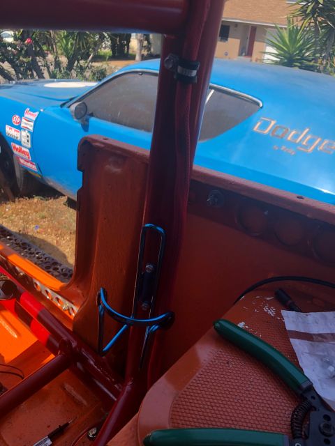 1992 Jeep Wrangler - The interior of a blue Dodge race car shows orange panels and a red roll cage, with tools visible on the seat.