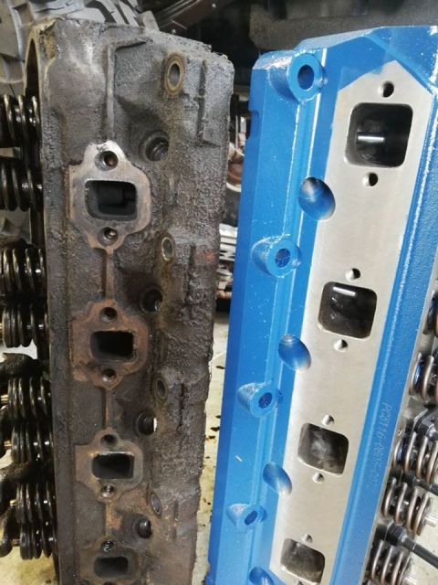 1996 Ford Bronco - Comparison of a used engine cylinder head next to a freshly painted blue one.