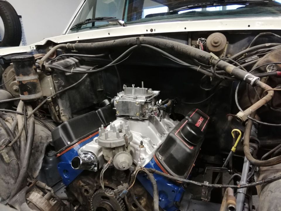 Engine bay with V8 engine, carburetor, and "RACING" valve cover