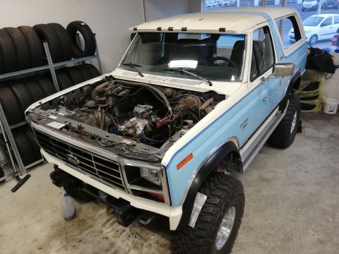 1996 Ford Bronco - This 1980 Ford Bronco is parked indoors with its hood up, revealing the engine bay.