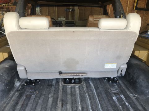 1980 Ford Bronco - The rear seat of a vehicle is shown from the back, mounted in a cargo area.