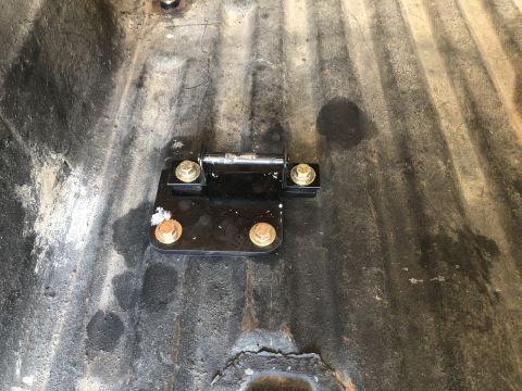 1980 Ford Bronco - A mounting bracket is secured to the floor of a vehicle with several bolts.