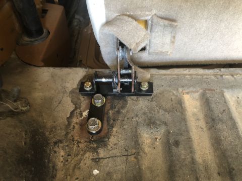 1980 Ford Bronco - Close-up of a seat mounting bracket attached to the floor of a vehicle.