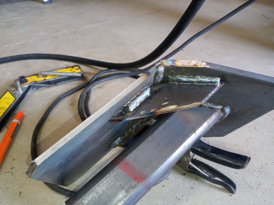 Welded metal brackets and cables on a concrete floor