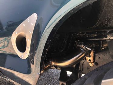 1979 Ford Bronco - Custom exhaust pipe installation near a fender vent on a vehicle.
