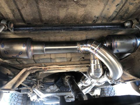 1979 Ford Bronco - Custom exhaust system installed on a vehicle, polished stainless steel piping and dual mufflers.