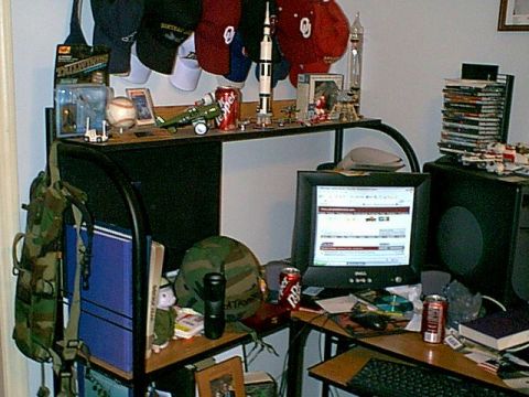 1988 Ford Bronco - A cluttered desk displays a computer, model airplane, baseball, and various hats.