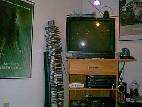 1988 Ford Bronco - A collection of media and electronics are displayed on a wooden stand next to a large television.