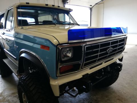 1996 Ford Bronco - Front view of a two-tone Ford Bronco with a blue stripe on the hood.