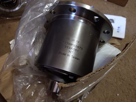 1996 Ford Bronco - A close-up view of a new differential gear part, still in its protective packaging, with manufacturing details visible.