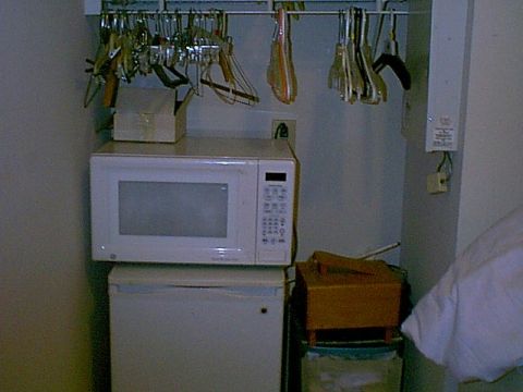 1988 Ford Bronco - Interior view of a closet containing a microwave, mini-fridge, and numerous hangers.