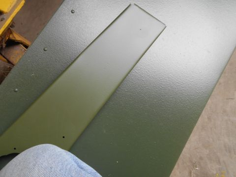 1992 Ford Bronco - Two green painted metal parts are shown, one with a raised strip, and a person's leg in jeans is in the foreground.